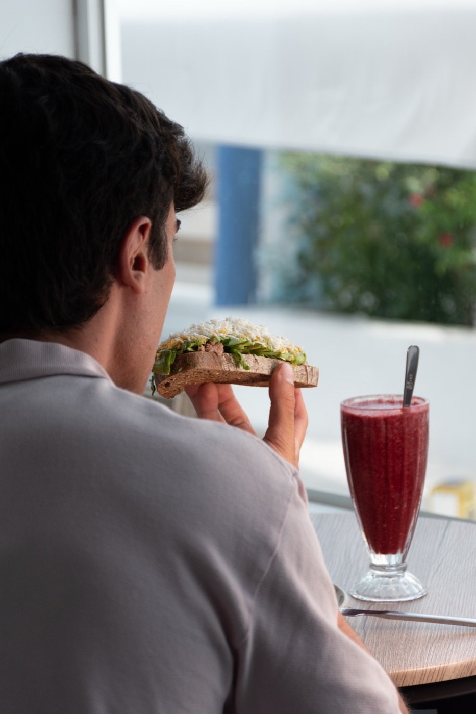 Cliente disfrutando de sándwich y batido